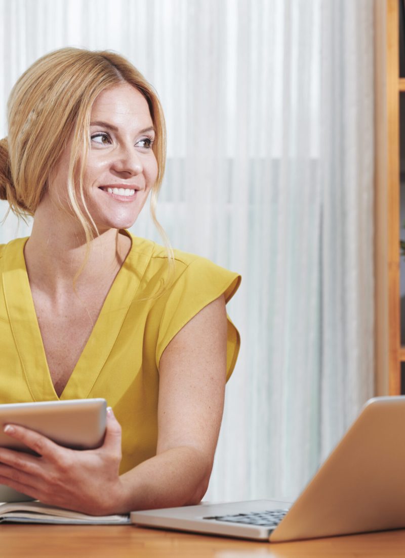 Young pretty business woman working at table in her office