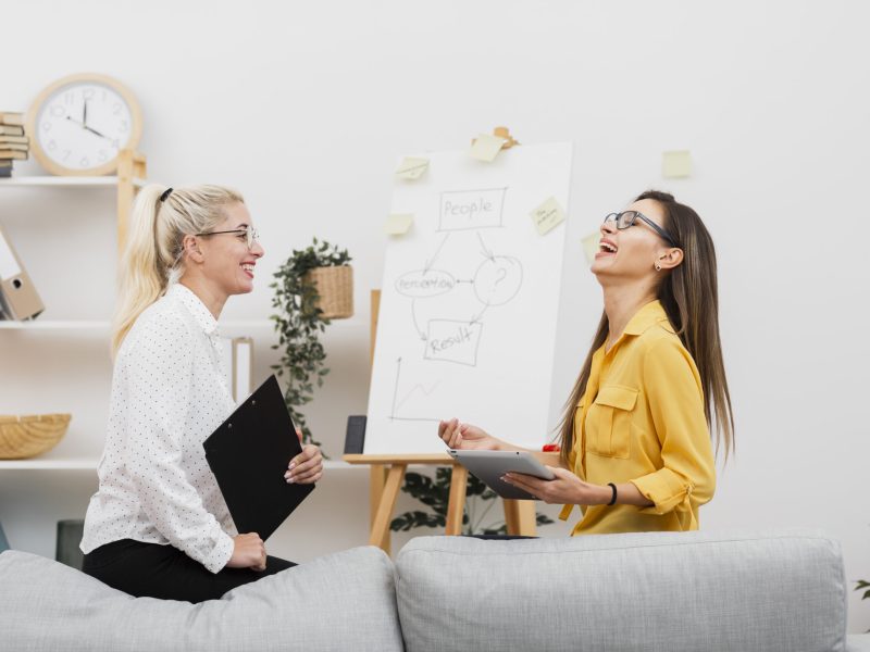 lateral-view-smiling-women-holding-tablet-clipboard