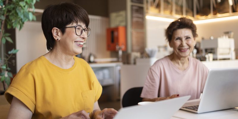 senior-women-spending-time-together-cafe-working-their-laptops